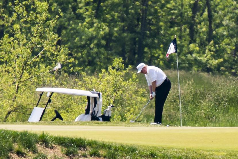 Trump durante realizar un tiro durante su escapada para jugar golf en Virginia. (Agencia EFE)