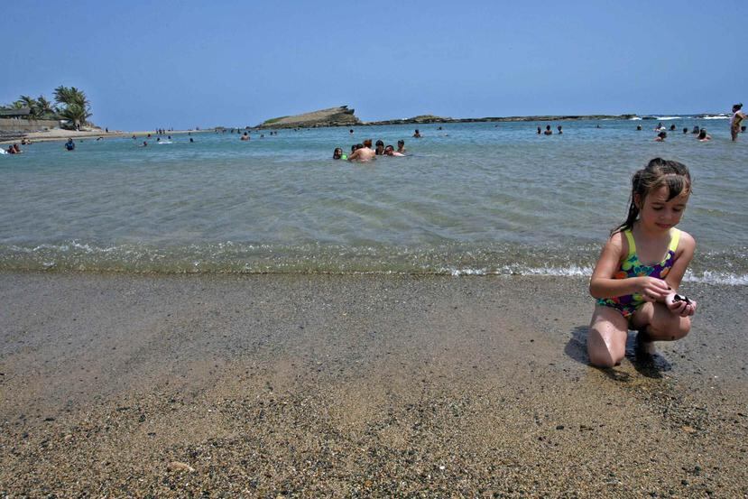 Una niña recoge piedras a la orilla de la Playa Sardinero, en  Hatillo. (Archivo GFR Media)