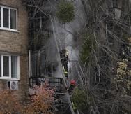 Bomberos ucranianos tratan de apagar un incendio en un edificio que fue alcanzado por misiles rusos, en Kiev, Ucrania.