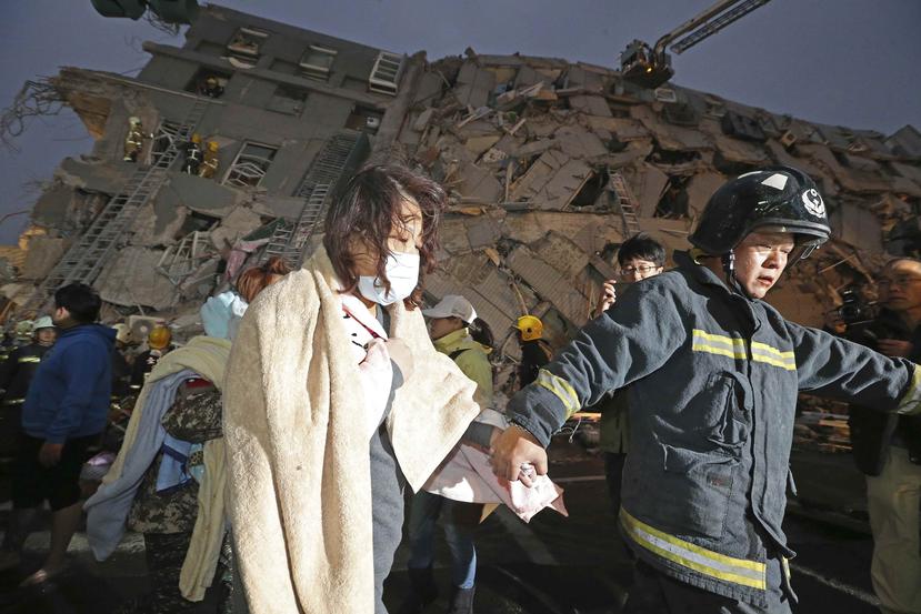 Una mujer es rescatada de uno de los edificios que colapsó.