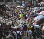A woman carries a basin with her belongings at the Petion-Ville market in Port-au-Prince, Haiti, Sunday, July 11, 2021, four days after the assassination of Haitian President Jovenel Moise.
