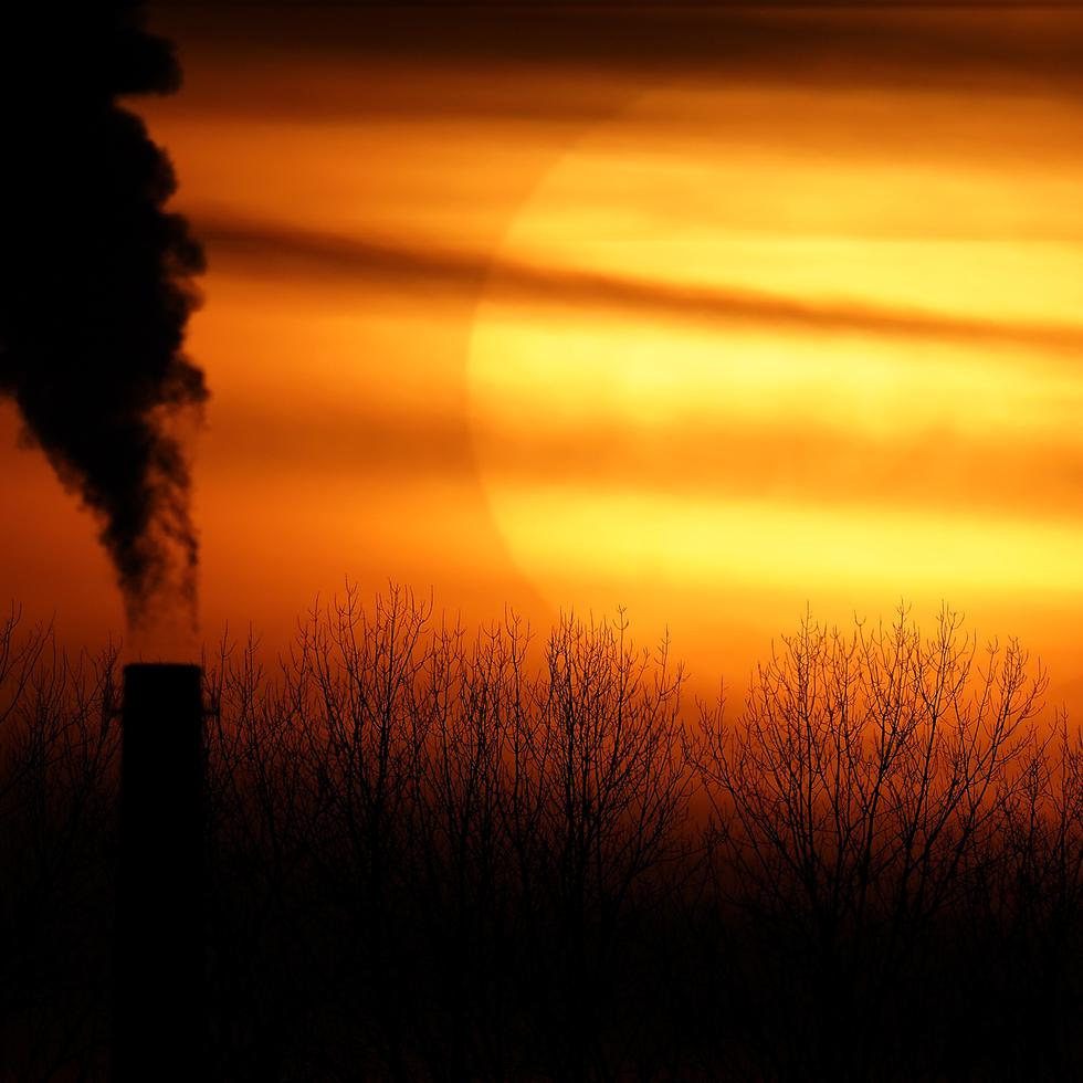 FILE - Emissions from a coal-fired power plant are silhouetted against the setting sun, Monday, Feb. 1, 2021, in Independence, Mo. (AP Photo/Charlie Riedel, File)