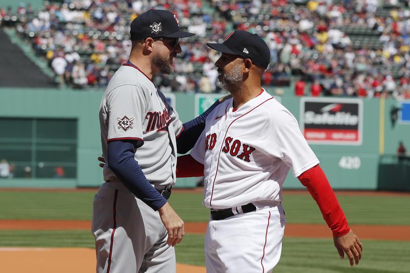 El dirigente puertorriqueño de los Red Sox Alex Cora saluda al manager de los Twins Rocco Baldelli previo al partido.