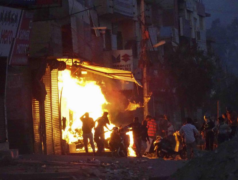 Incendian una tienda durante la violencia entre grupos religiosos en Nueva Delhi durante la visita del presidente estadounidense Donald Trump. (AP)