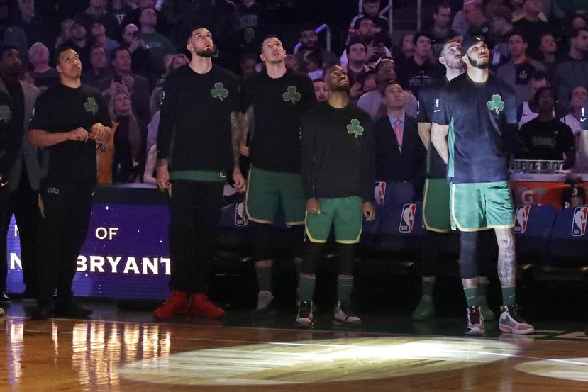Los jugadores de los Celtics de Boston miran un homenaje en video para el fallecido Kobe Bryant, antes del partido ante los Warriors de Golden State. (AP)