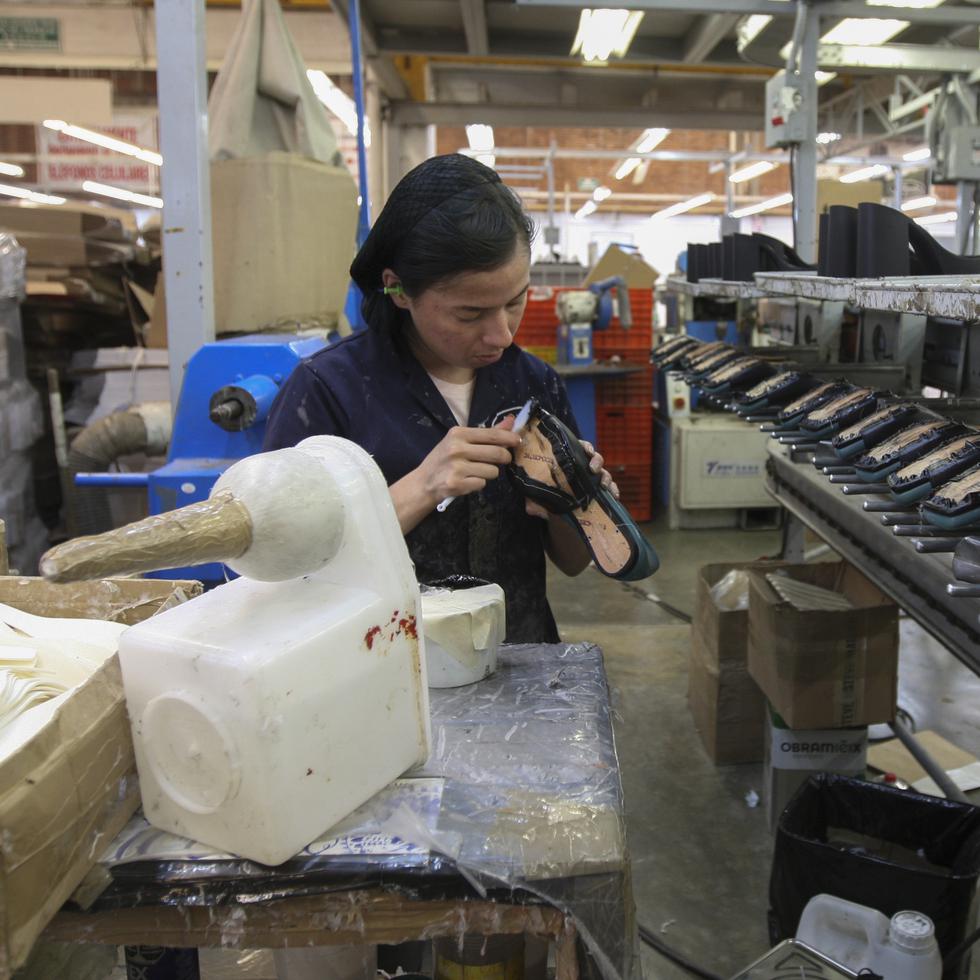 Una mujer trabaja en una maquiladora de calzado en León, México.