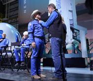 Desde la izquierda, Oliver Daemen, Mark Bezos y Wally Funk presencian cuando Jeff Bezos, segundo desde la derecha, recibe su insignia de alas de astronauta elaborada por Blue Origin de manos del exastronauta de la NASA, Jeff Ashby, a la derecha, quien ahora está con Blue Origin.