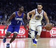 Stephen Curry, alero de los Warriors de Golden State, dribla a Jawun Evans, de los Clippers de Los Ángeles, en el partido disputado el sábado 6 de enero de 2018. (AP /Alex Gallardo)