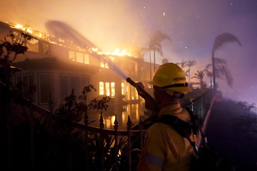 Un bombero trabaja para combatir las llamas en un edificio en llamas, el miércoles 11 de mayo de 2022 en Laguna Niguel, California.