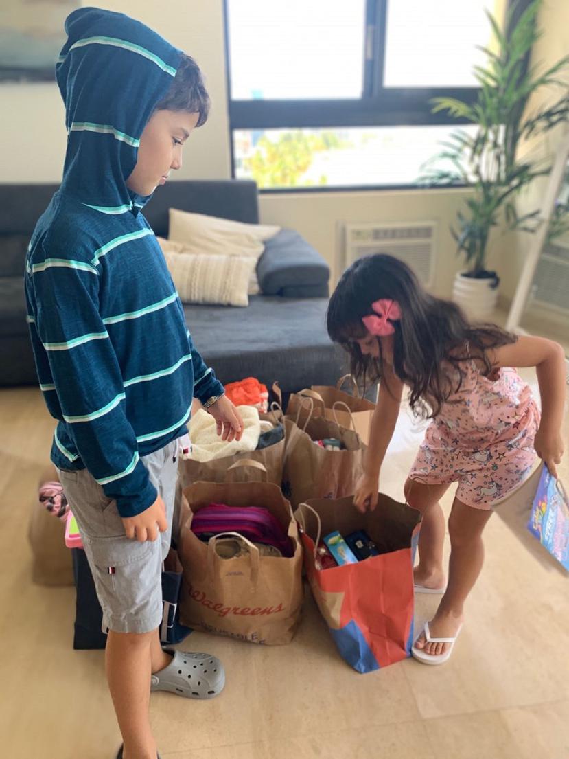 Diego y Mila organizan los juguetes y la ropa que han recibido como donativos de otras personas. (Suministrada)