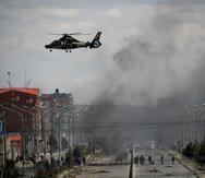 En esta foto de archivo del 19 de noviembre de 2019, un helicóptero del Ejército sobrevuela la carretera que conduce a la planta estatal de llenado de gas Senkata en El Alto, en las afueras de La Paz, Bolivia, mientras partidarios del expresidente Evo Morales hacen barricadas. El 11 de marzo de 2021 la Fiscalía de Bolivia ordenó la detención del excomandante de las Fuerzas Armadas y del exjefe de la Policía por haber solicitado la renuncia de Morales durante la crisis política.