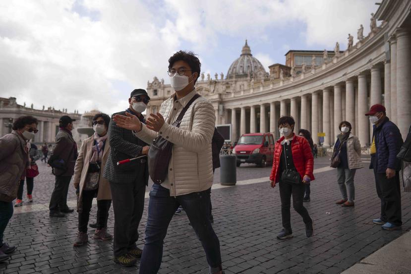 Turistas con mascarillas recorren la plaza de San Pedro en el Vaticano. (AP)