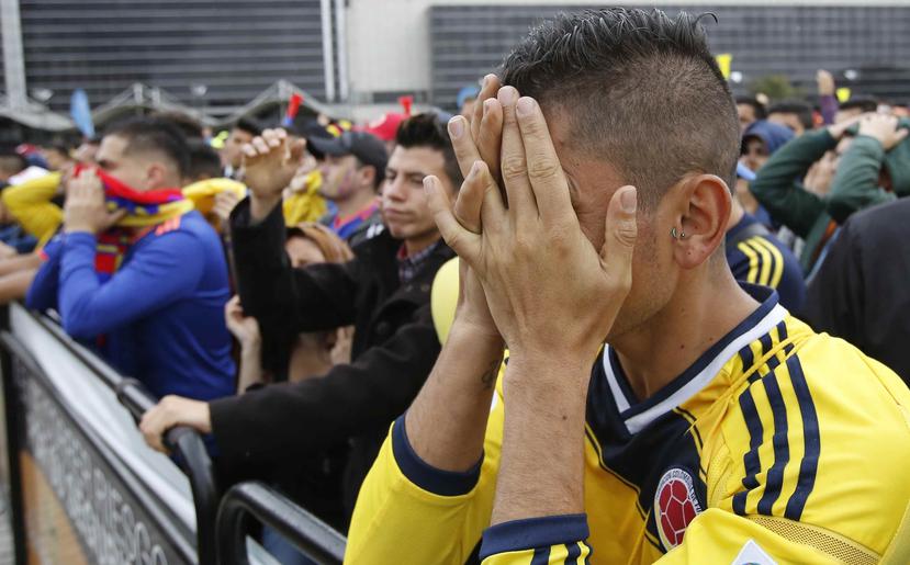 Un aficionado de Colombia se cubre el rostro durante la transmisión del partido entre esa selección sudamericana e Inglaterra en el Mundial de Rusia, en Bogotá. (AP)