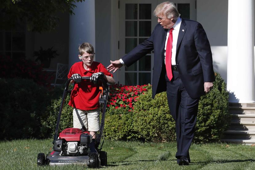 El presidente Donald Trump saluda a Frank Giaccio, de 11 años, mientras poda el jardín de la Casa Blanca. (AP)