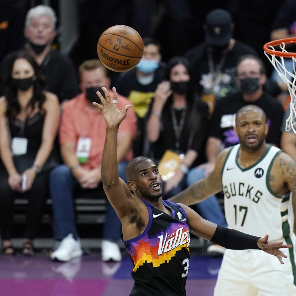 Chris Paul, de los Suns, tira al canasto ante la mirada de P.J. Tucker (17), de los Bucks, en el primer juego de las finales de la NBA.