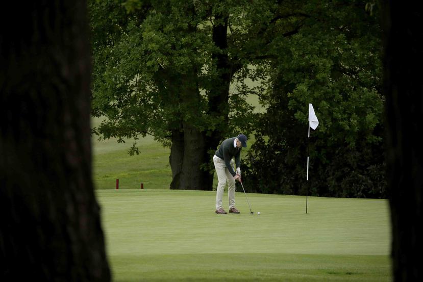 Un golfista golpea una bola en el club de golf Sunningdale tras su reapertura luego de que el gobierno alivió la cuarentena contra el coronavirus en Inglaterra.