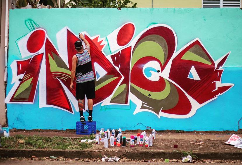 El artista urbano Índigo trabaja en un mural en la ciudad de Bayamón. (Suministrada)
