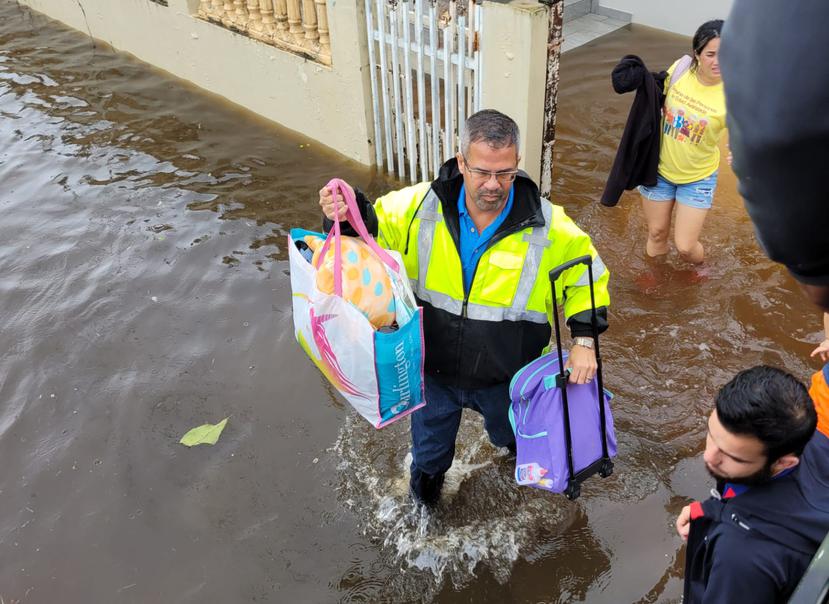 El alcalde de Vega Baja, Marcos Cruz, ayuda en el desalojo de una familia cuya casa se inundó a causa del huracán Fiona