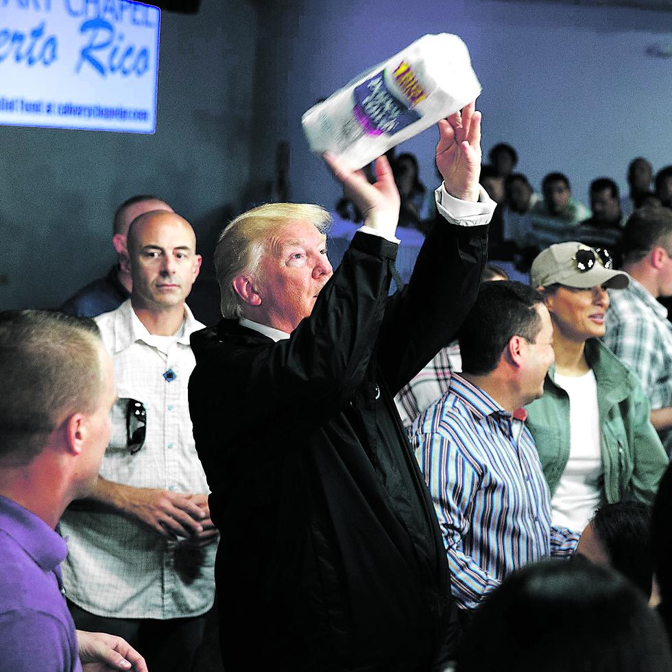 FILE - In this Oct. 3, 2017 file photo, President Donald Trump tosses paper towels into a crowd at Calvary Chapel in Guaynabo, Puerto Rico. Trump congratulated Puerto Rico for escaping the higher death toll of "a real catastrophe like Katrina" and heaped praise on the relief efforts of his administration without mentioning the sharp criticism the federal response has drawn. (AP Photo/Evan Vucci, File)