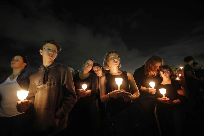 Gente participa en una vigilia en memoria de 17 estudiantes y maestros abatidos en la escuela secundaria Marjory Stoneman Douglas en Parkland, Florida, 19 de febrero de 2018. (AP)