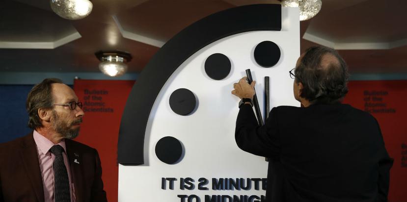 Robert Rosner (derecha) y Lawrence Krauss (izquierda), miembros del Boletín de los Científicos Atómicos, al momento de mover el minutero del Reloj del Apocalipsis. (AP)