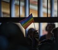 Una persona sostiene una bandera de las comunidades LGBTTQIA+.