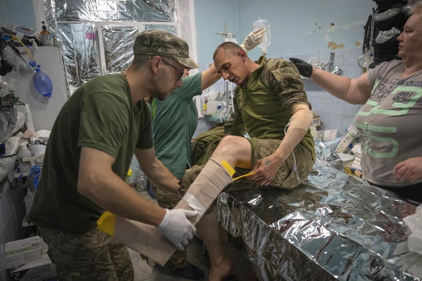 Médicos militares prestan primeros auxilios a soldados ucranianos en un centro de estabilización cerca de Bájmut, en la región de Donetsk, Ucrania, el miércoles 24 de mayo de 2023.