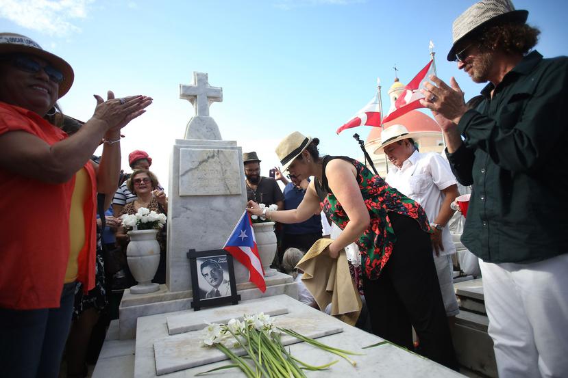 Danilu Santos, hija de Daniel Santos, coloca la bandera de Puerto Rico en la tumba del cantante.