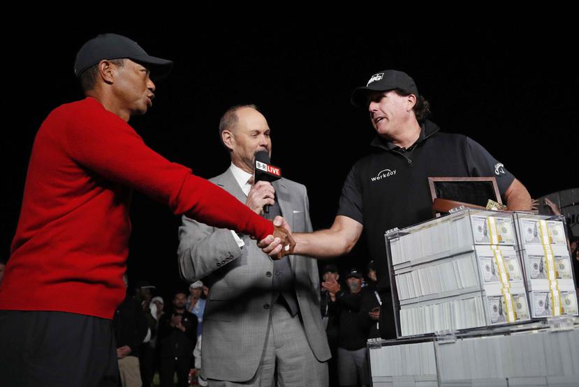 Tiger Woods, izquierda, estrecha la mano de Phil Mickelson, derecha, luego de perder un duelo por nueve millones de dólares en el campo de golf Shadow Creek. (AP)