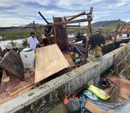 Residentes ven lo que quedó de sus pertenencias tras el paso del ciclón por la localidad de Surigao del Norte en el centro de Filipinas.