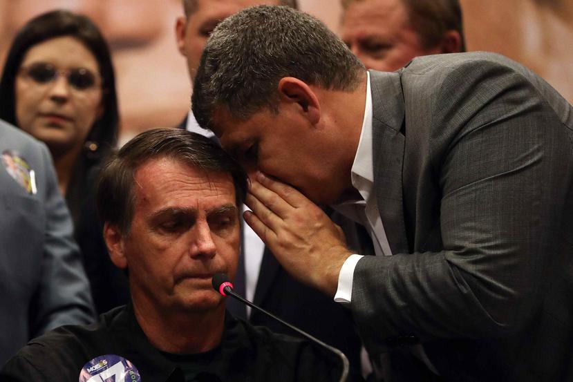 El candidato ultraderechista a la presidencia de Brasil, Jair Bolsonaro (i), habla con el presidente del partido PSL, Gustavo Bebianno (d). (EFE)