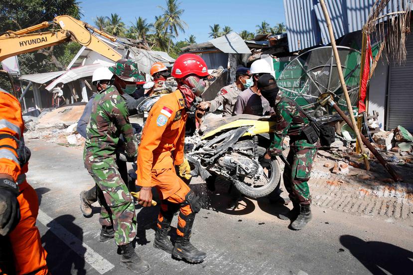 Miembros de los servicios de rescate retiran una motocicleta de entre los escombros tras un terremoto que sacudió Tanjung (Indonesia). (GFR Media)