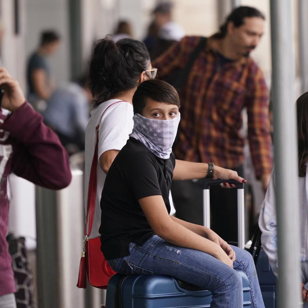 Viajeros usan mascarillas como medida de prevención contra el contagio de coronavirus en el aeropuerto Love Field, en Dallas.