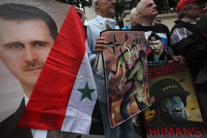 Serbios favorables al presidente sirio, Bashar al Assad, muestran pósters suyos y del presidente ruso, Vladímir Putin, durante una manifestación contra el ataque selectivo por parte de EE.UU., Francia y Reino Unido. (Agencia EFE)