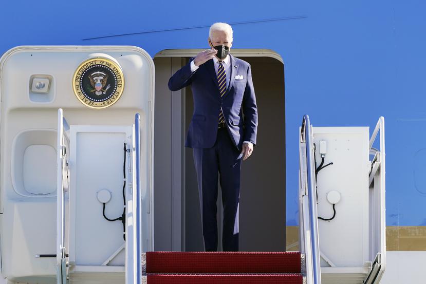El presidente Joe Biden saluda desde lo alto de los escalones del Air Force One en la base de la Fuerza Aérea Andrews, Maryland.