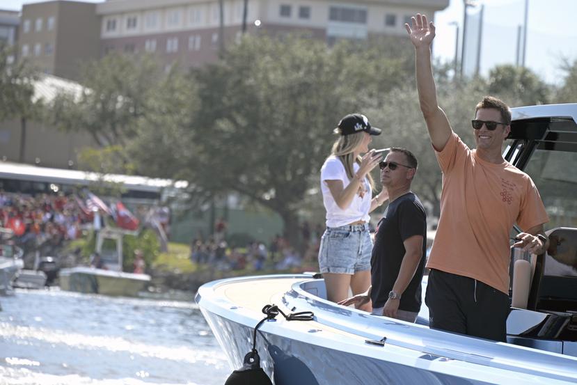 Tom Brady saluda a los fanáticos en la orilla del río Hillsborough en Tampa durante el desfile de botes de los Buccaneers.