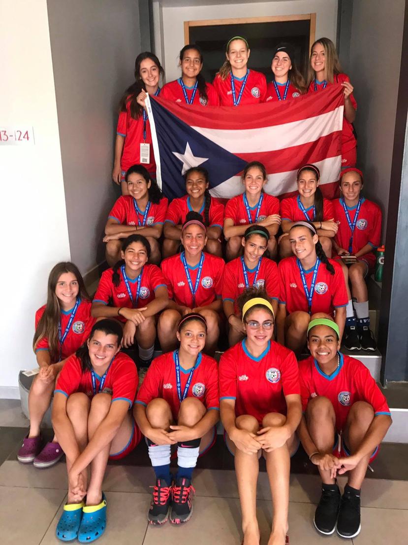 Las integrantes de la Selección Sub-17 posan con la bandera de Puerto Rico previo al inicio de la eliminatoria Haití. (Suministrada)