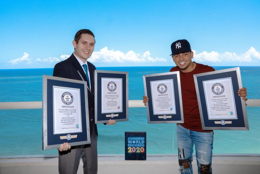 Ralph Hannah, Adjudicador Oficial de Guinness World Records, muestra junto a Ozuna los cuatro récords del artista. (Albizu Albikon / Guinness World Records)