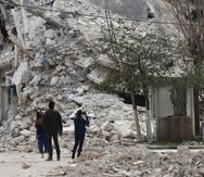 Personas observan un edificio destruido por un terremoto reciente, el lunes 27 de febrero de 2023, en Alepo, Siria. (AP Foto/Omar Sanadiki)