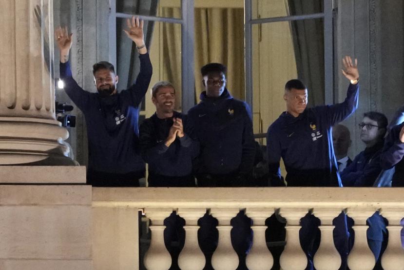 Olivier Giroud (izquierda), Antoine Griezmann (segundo de izquierda a derecha), Kylian Mbappé (derecha) y los demás seleccionados de Francia agradecen al público desde un balcón del Hotel Crillon, en París.