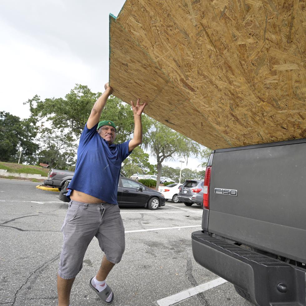 Jesus Rodrigues loads wood in his vehicle outside a Home Depot store in preparation for the arrival of Hurricane Ian, Monday, Sept. 26, 2022, in Orlando, Fla. Ian was growing stronger as it approached the western tip of Cuba on a track to hit the west coast of Florida as a major hurricane as early as Wednesday. (AP Photo/Phelan M. Ebenhack)
