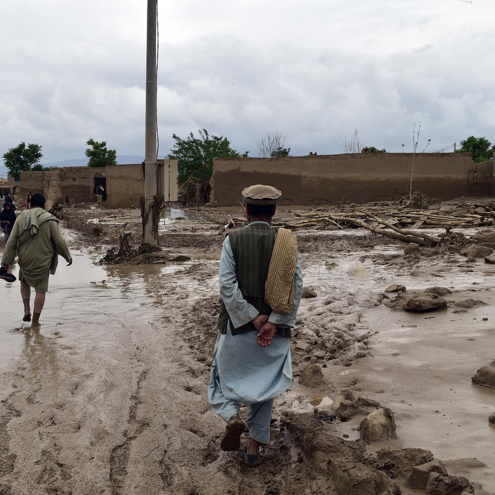 Varias personas visitan la zona donde las intensas inundaciones destruyeron viviendas y dejaron numerosos fallecidos, en la provincia de Baghlan,.
