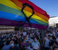 La bandera arcoíris con un listón negro ondea durante una protesta en contra del asesinato de Samuel Luiz, en la Puerta del Sol, el lunes 5 de julio de 2021, en Madrid. (AP Foto/Bernat Armangue)