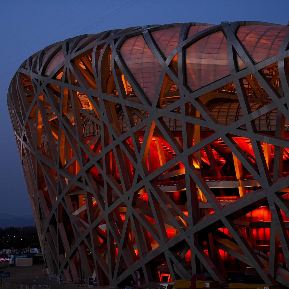 El Estadio Nacional y la Torre Olímpica iluminadas de rojo. Pekín aceptó albergar los Juegos de Invierno cuando otros países se retiraron de la contienda.