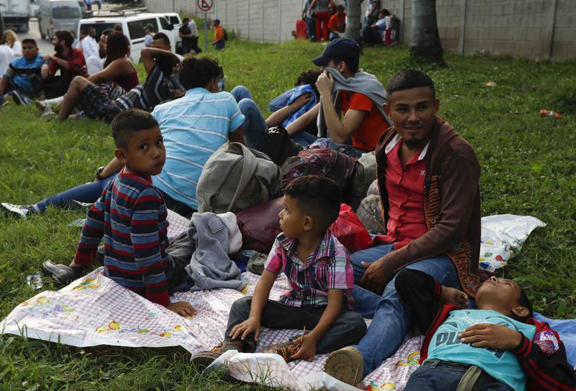 Freddy Rivas (segundo por la derecha), natural de Tocoa, Honduras, sus hijos Josué (izquierda) y Elkin (centro) y su hermano Mario esperan la llegada de más migrantes a una caravana que viajará hacia la frontera de Estados Unidos, en San Pedro Sula, Hondu