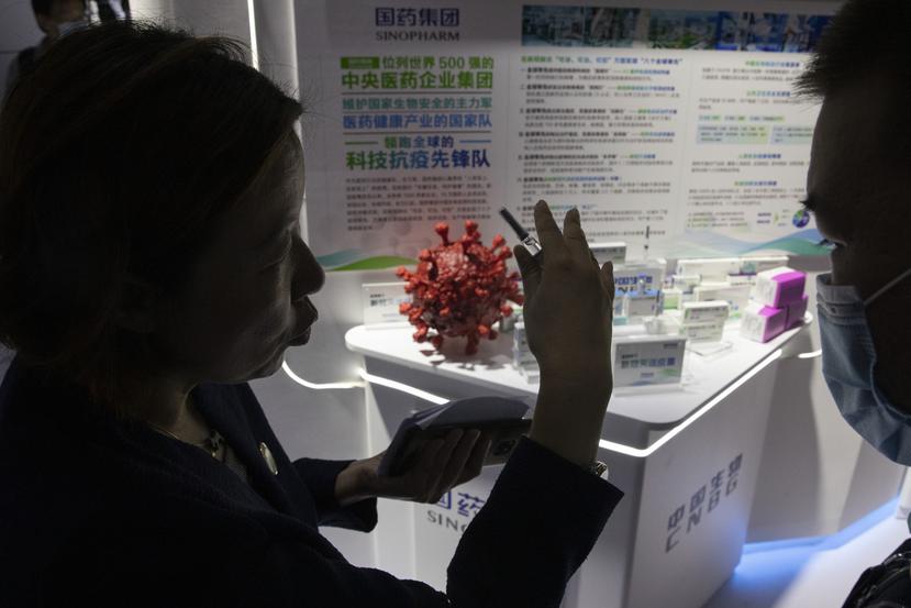 Una promotora habla sobre la vacuna contra el COVID-19 producida por la subsidiaria de Sinopharm, CNBG, durante una feria comercial en Beijing.