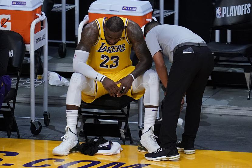 LeBron James demuestra su frustración sentado en el banco de los Lakers durante el sexto y último partido de la serie ante los Suns de Phoenix el jueves.