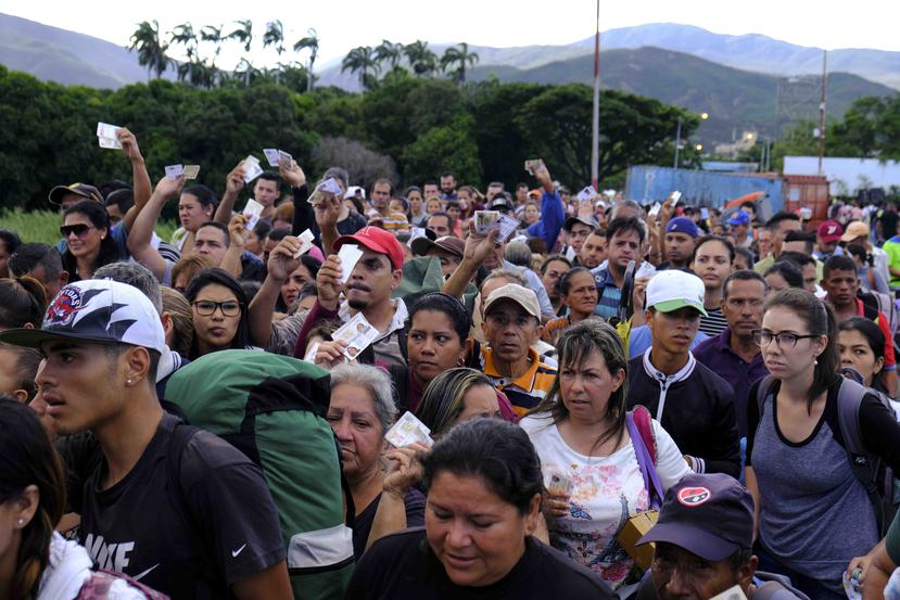 Venezolanos con sus documentos de identidad se aprestan a cruzar el puente internacional Simón Bolívar a Cúcuta, Colombia, sábado 8 de junio de 2019. (AP/Ferley Ospina)