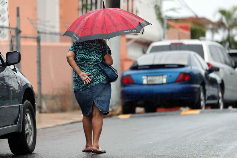Una ciudadana camina con un paraguas por el área de Barrio Obrero. (GFR Media)