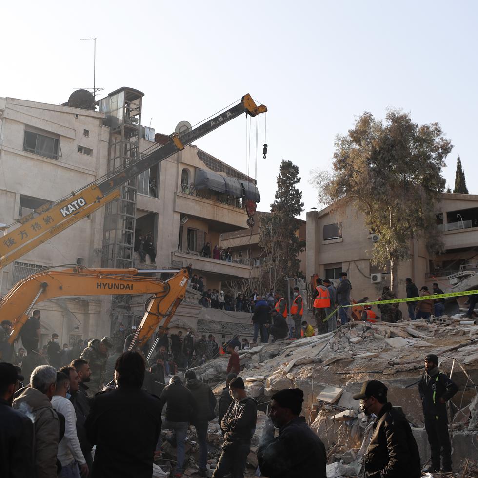 Personal del servicio de emergencias realiza tareas en un edificio impactado por un ataque aéreo israelí en Damasco, Siria.